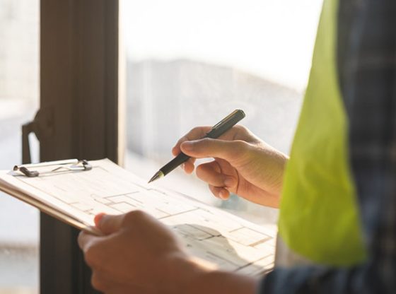 Man Surveying a Home with clipboard