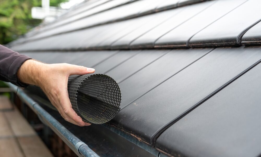Man,Puts,A,Gutter,Mesh,To,The,Rain,Gutter,To