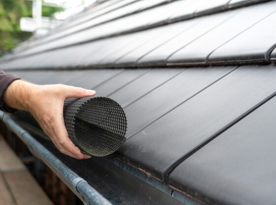 Man,Puts,A,Gutter,Mesh,To,The,Rain,Gutter,To